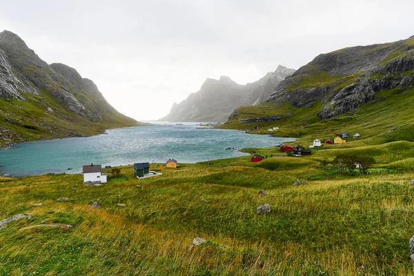 Dağlarla çevrili güzel bir koyda renkli İskandinav evleri ve Norveç Lofoten Adaları Bunes Beach ve Vinstad yakınlarındaki küçük bir köy