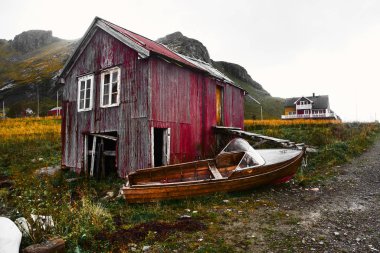 Norveç'te Lofoten Adaları Vinstad kıyısında eski hasarlı ve yıpranmış ahşap tekne evi