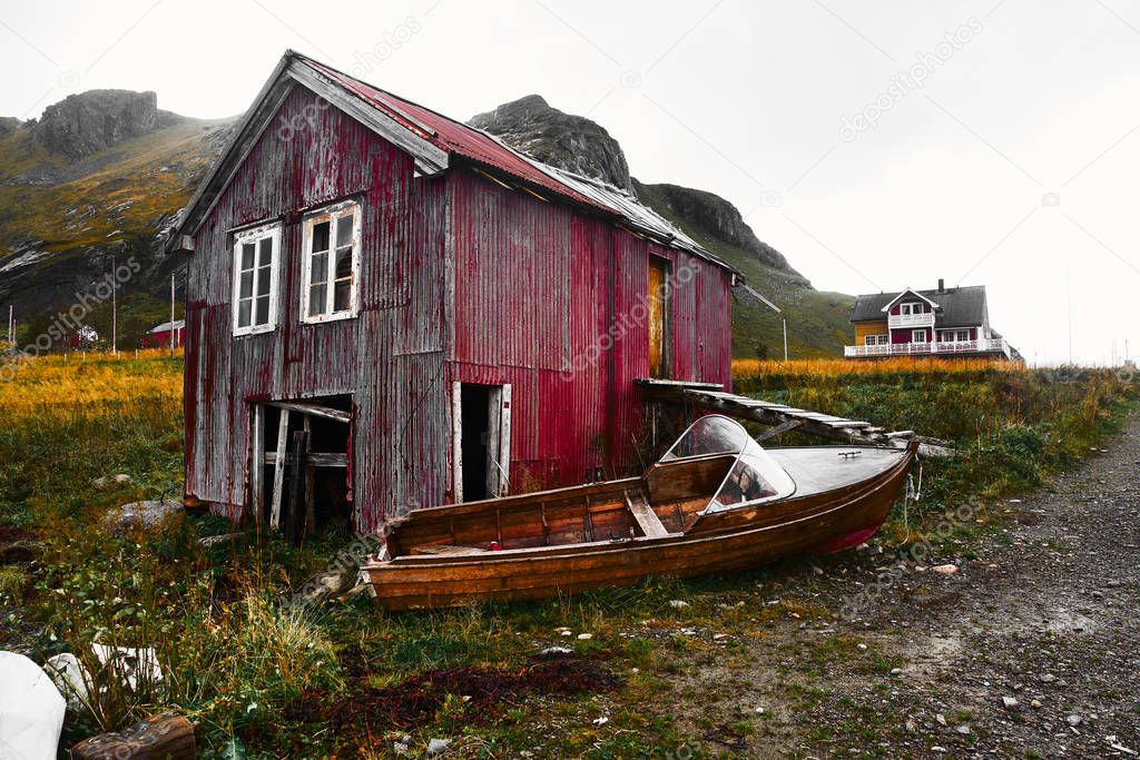 Old damaged and weathered wooden boat house at the coast of Vinstad on Lofoten Islands in Norway