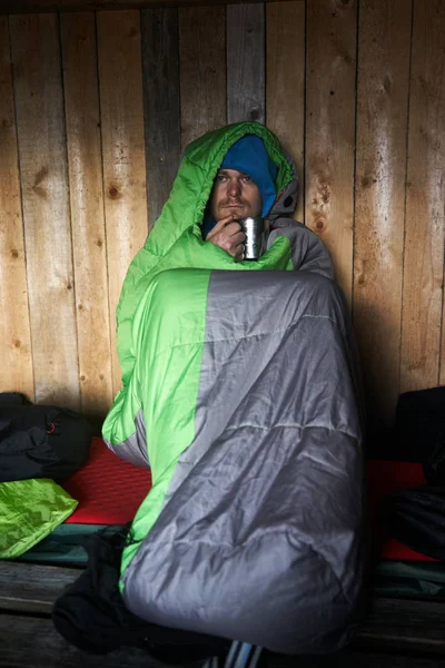 노르웨이 로포텐 제도에서 침낭에 커피를 마시는 여행자의 초상화 스톡 사진