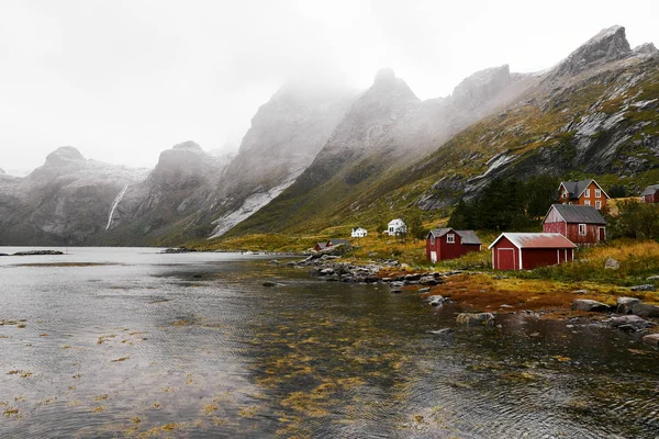 Norveç'te Lofoten Adaları arka planda dağlar ile Vinstad kıyısında uzak bir eski balıkçı köyüpanoramik görünümü.