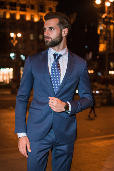 Style and business. Handsome young man looking away while standing outdoors