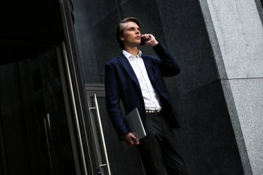 Toplantıya geç kaldım! Onun laptop taşıyan ve açık havada duran ise onun smartphone kullanarak yakışıklı delikanlı