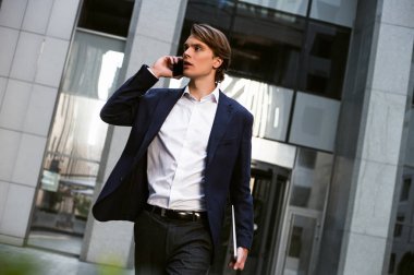 On dakika içinde olacak! Onun laptop taşıyan ve açık havada duran ise onun smartphone kullanarak yakışıklı delikanlı