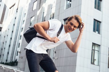 Harika bir gün daha. Uzaklıkta açık havada yürürken gülümseme ile seyir yakışıklı genç 