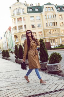 Sohbet etmek için mükemmel ruh hali. Gülümseme ve açık havada duran ise cep telefonu üzerinde konuşurken kameraya bakarak siperde güzel genç kadın