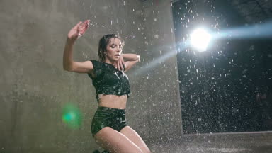 Islak kadın dansçı siyah beden takım elbise içinde yağmur ve su sıçramalarına katta modern dans gerçekleştirir. Su altında dans sırasında yerde kapalı önce dans dansçı