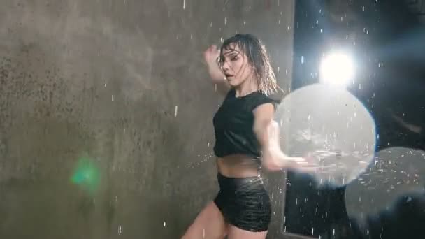 Danza moderna joven mojada bajo la lluvia en el escenario. bailarina húmeda bailarina dando vueltas alrededor de sí misma en el estudio bajo el agua de lluvia — Vídeos de Stock