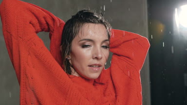 Kırmızı kazaklı stüdyo su yağmur altında duygusal modern dans dans seksi dansçı kız, o saçları ve kamera, seyir ile su damlaları su sıçramalarına yakın çekim