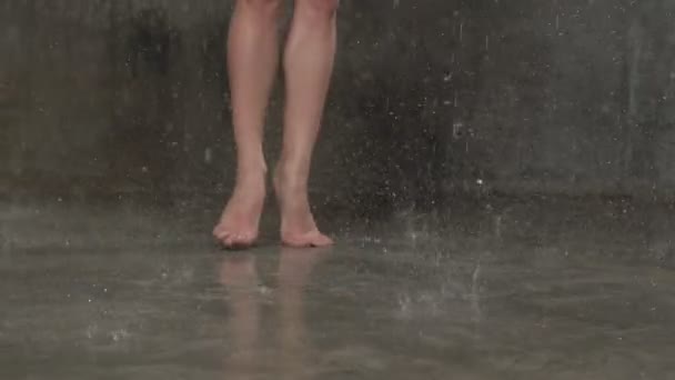 Gros plan pieds de ballerine qui danse des éléments de ballet de mouvement pendant la pluie d'eau à l'intérieur au ralenti. Danse dansante sous la pluie — Video