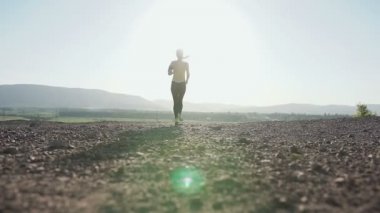 Dağda günbatımında - kadın atlet runner hızlı sprint çalışan genç kadın iz çalışan. Çalışan spor ayakkabı ve spor spor kız dağlarda günbatımı giyer. Çalışan