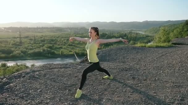 Mladá žena rozcvičení před fitness cvičení při východu slunce v noci. Dívka, strečink venku. Běžkyně dělá protahovací cvičení před spuštěním venkovní v hoře — Stock video