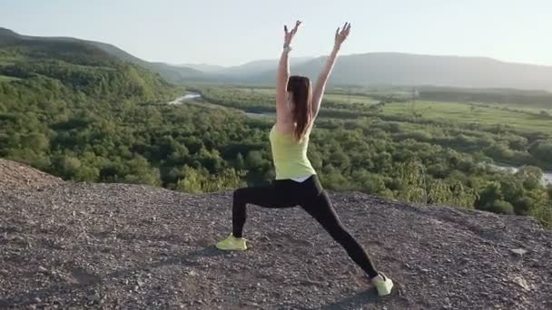 Jonge atleet vrouw warming-up voor fitnesstraining bij zonsopgang in de ochtend. Meisje doet buiten rekken in de achtergrond-rivier op top van berg. Vrouwelijke atleet stretching oefening doen — Stockvideo