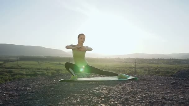 Vrouw warming-up voor fitnesstraining bij zonsopgang in de ochtend. Vrouw die zich uitstrekt buiten in berg boven de rivier. Vrouwelijke atleet stretching oefening voordat u buiten doen — Stockvideo