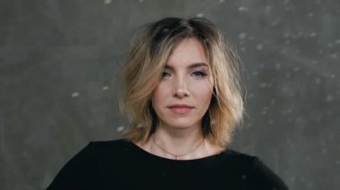 Yakın çekim. Toz veya beyaz un kirli siyah elbise giymiş bir güzel sarışın kız portresi, kameraya görünüyor. Hangi beyaz un bir genç kadının portresi sanat