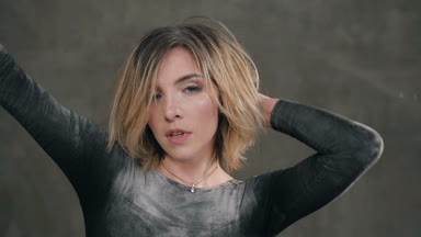 Yakın çekim. Sanat kapalı arka plan gri üzerine dans eden güzel bir sarışın kız portresi, o kamera kız bakar toz veya beyaz unundan kirli siyah elbise giymiş