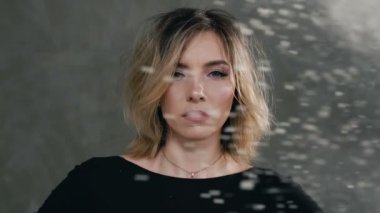 Kim hangi flyaing sıçramalarına siyah giysilerle beyaz toz veya beyaz un giymiş güzel bir sarışın kızın yakın çekim, kız kameraya benziyor. Kim sinek üzerinde genç bir kadın portresi sanat