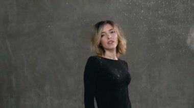 Şirin kız arka planda gri bir duvar üzerinde seyir belgili tanımlık fotoğraf makinesi ve gülümsüyor beyaz toz veya un taneleri sarsıldı Studio ayakta