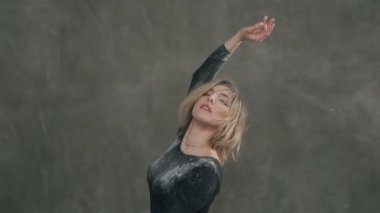 Siyah gövde elbiseli güzel ifade kadın dansçı duman veya beyaz toz bulutları Studio dans ediyor. Genç ve güzel Balerin dansçı vücut siyah tişört, şort ve balerin ayakkabıları giymiş