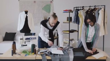 Giysi ve terzi tasarımcı kıyafetleri modern küçük atelier adlı yeni bir koleksiyon geliştirir. Çalışma günü başarıyla tamamlanması. Moda tasarımcıları onların çalışmalarına odaklandık