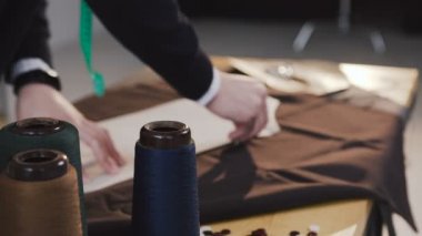 Moda Tasarımcısı veya bir terzi kumaş ile stüdyo araçları terzilik tam çalışma. Desen, makas, şerit metre ve bir dikiş makinesi. Terzi işyeri. Terzi kroki çizgi çizme