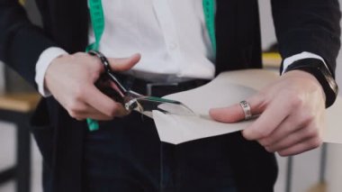 Terzi ve makas kesim kumaş atelier Studio ile moda tasarımcısı. Yakın çekim: makas doku keser. Çizimler kesme yakın çekim. Terzi ve tutar skeçler el ile keser bir