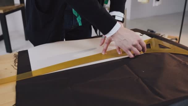 Дизайнер моди або кравець малює лінію на тканині в студії ательє. Розробка ескізу одягу — стокове відео