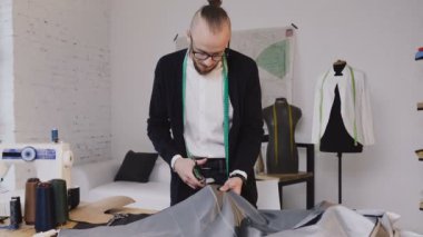 Yakışıklı terzi kesim kumaş deseni tebeşir işaretleri aşağıdaki gibi büyük makas ya da makası kullanarak
