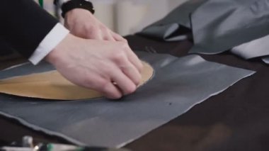 Yakın çekim. Yakışıklı terzi ya da moda onun stüdyosunda çalışan tasarımcı şablonu kumaş üzerinde çizim. Yaratıcı kim çizim bir parça sabun kullanarak çizimler ile doku üzerinde çizgiler terzi bir eseri