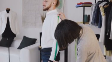 Profesyonel moda tasarımcısı veya terzi alarak ölçülerini dikiş terziler dükkanında uygun. Terzi teyp ölçme ile sewinf yeni bir ceket ölçülerini müvekkili için yapar. Müşteri ile