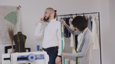 Profesyonel moda tasarımcısı veya terzi alarak ölçülerini dikiş terziler dükkanında uygun. Terzi teyp ölçme ile sewinf yeni bir ceket ölçülerini müvekkili için yapar. Müşteri ile