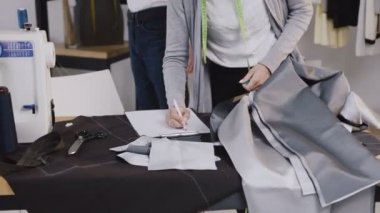 Moda endüstrisi, Genç kadın ve adam. Ölçüm bandı ve işadamı müşterinin atelier yeni ceket için terzi. Stilist istemci kol bandı ile uzunluğu ölçme