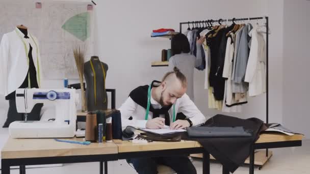 Deux créateurs de mode travaillant au bureau avec différents outils de couture vêtements de sable. Je travaille sur une nouvelle collection ensemble. Créateur de mode et tailleur caucasien — Video