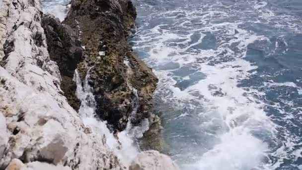 Wellen, die über Steine schwappen. Meereswellen, die auf die felsige Küste der Adria in Budva treffen. Montenegro, Petrovac — Stockvideo