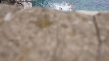 Üstten görünüm. Berrak deniz, katmanlı kayalar ve Budva, Karadağ için güzel doğa manzarası. Azure sahil, deniz dalgaları kayalara karşı yendi.