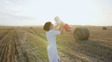 Bir ışık içinde güzel kadın onun büyüleyici erkek bebek ve çevresinde dönmeye başlar ve gülümsüyor yüksek yükseltir. Gün batımında oğlu alanında oynamaktan mutlu genç kadın vakit