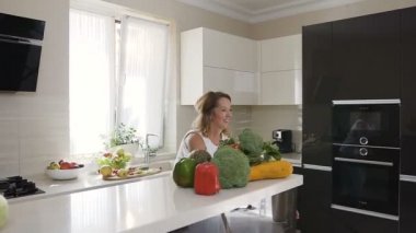 Sevgi dolu bir anne İlköğretim Okulu yaş evde sevgi küçük kızı mutfakta kucaklayan zaman gülümseyerek. Hafif bir giyim güzel kadın onun sevimli bebek kız yükseltir ve sevinçle başlar