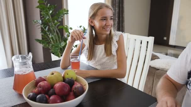 Beautiful family having breakfast together in the kitchen at home. Teen girl drinking juice and her father is drinks coffee at the kitchen table. Happy moment — Stock Video