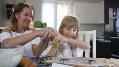 Oynak anne ve kızı bıyık hamur ürünleri bisküvi mutfakta birlikte evde pişirme zaman yapıyoruz. Küçük kızı annesiyle kurabiye pişirme için hamur hazırlama iyi eğlenceler