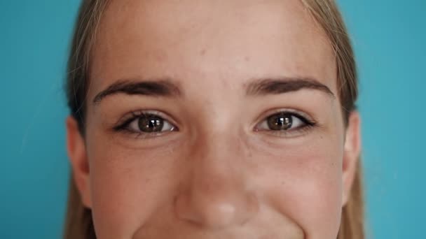 Primer plano de una cara de chica linda adolescente. Un retrato. Cara de cerca de una hermosa rubia con ojos oscuros y hermosa sonrisa — Vídeo de stock