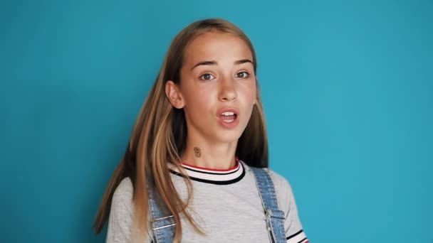 Portrait of a beautiful teen girl who expresses different emotions of happiness, surprise, shock. Face of a girl with big brown eyes and long hair. Happy schoolgirl or student — Stock Video