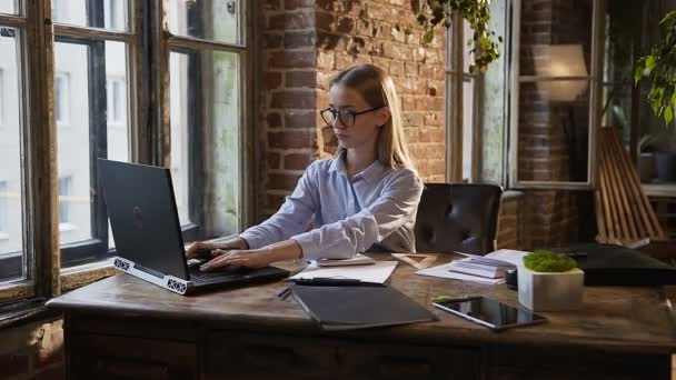 Vackra business tjej arbeta med dokument och laptop dator arbetande tid i moderna office arbetsplatsen koncept. Kaukasiska ung kvinna arbetar med finansiella dokument på arbetsplats på kontoret — Stockvideo