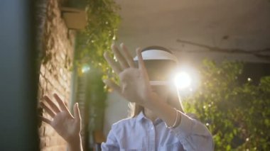 Yakın çekim. Sanal gerçeklik kulaklık ofiste kullanan güzel kız. Genç kadın bir sanal gerçeklik gözlük kapalı akşam kullanır. Kızı 3d sanal gerçeklik kulaklık kullanmak