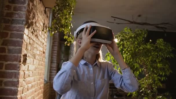 Vacker ung kvinna använder 3d virtuell verklighet headset. Virtuell verklighet spel. Student tjej med glädje använder huvud-monterad display. Framtiden är just nu — Stockvideo