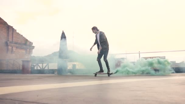 Handsome Hipster Guy Skateboarding Rides Colored Smoke Terrace Industrial Building — Stock Video