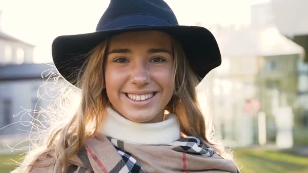 Närbild porträtt av vacker ung kvinna promenader, ser rak till kameran och leende. — Stockvideo