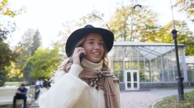 Kent parkta onun yürüyüş sırasında tne akıllı telefonda konuşurken güzel kız.