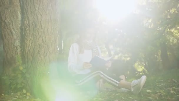 Mladé krásné blond vlasy žena čtení knih v městském parku. — Stock video