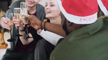 Neşeli arkadaşları tost sahip kutlamak Noel ve yeni yıl, yılbaşı ağacı önce rahat daire ise içerken. Köpüklü şarap ile yılbaşı partisinde gençlerin karışık yarış Grup