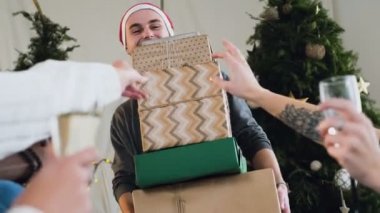 Neşeli mutlu adam santa claus şapka hediye kutuları bir sürü Noel arifesinde sevgili arkadaşları ve kız arkadaşı için tutuyor. Noel kutlamaları, yılbaşı ve partiler kavramı